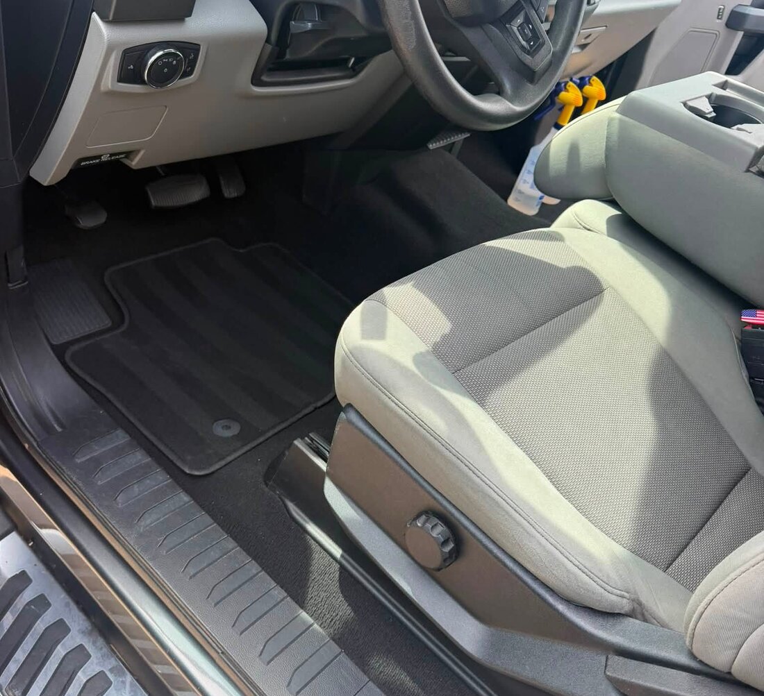 The same Ford Super Duty footwell after detailing, with clean carpet and a spotless mat