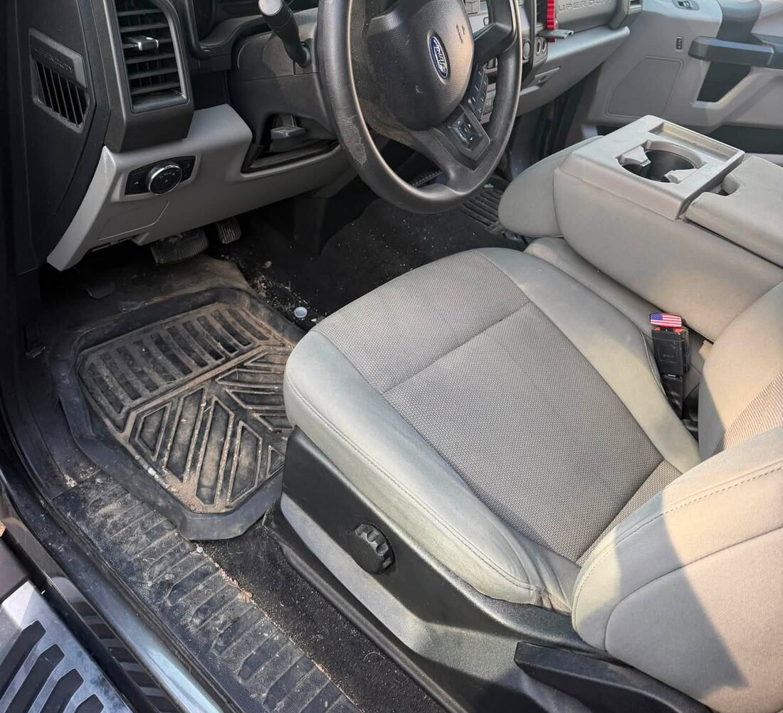Ford Super Duty driver footwell before detailing, with dirt and grit on the mat
